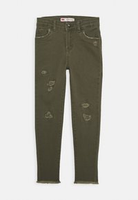 Pantalones vaqueros ajustados de color verde oliva, hechos de denim, con detalles rasgados y dobladillos deshilachados. Diseño de cinco bolsillos con cierre de botón.