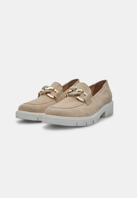 Le scarpe slip-on in suede beige presentano un doppio accentuato in catena dorata e una suola bianca spessa con dettagli intagliati per una migliore aderenza.
