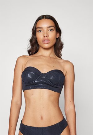 Tmavomodrý bandeau bikiny vrchol s lesklou textúrou, s tvarovanými pohármi a detailným prešitím pozdĺž okrajov.