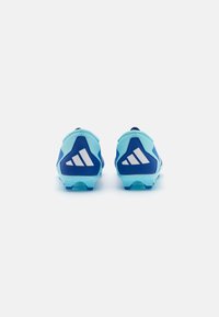 Crampons bleus avec des accents bleu clair, présentant un design texturé et un logo géométrique blanc distinct à l'arrière. Semelle en caoutchouc transparent.