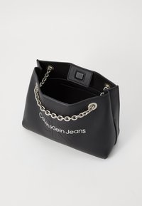 Borsa a tracolla in finta pelle nera con manico a catena argentata, dotata di logo e design minimalista. L'interno presenta un comparto aperto.