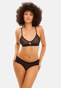Zwarte doorschijnende lingerie set met een driehoekige bralette met een uitsnijding in het midden en verstelbare bandjes, gecombineerd met bijpassende briefs met kantafwerking.