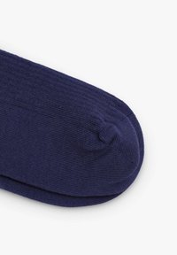 Calzino blu navy, texture a maglia, design con punta arrotondata, costruzione senza cuciture, senza motivi o dettagli visibili, aspetto minimalista.