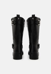 Botas altas de cuero negro con un acabado pulido, que cuentan con herrajes de hebilla plateada y cremalleras a los lados para un acceso fácil.