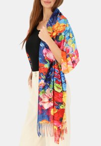 Kolorowy kwiatowy szal z wyrazistymi odcieniami niebieskiego, czerwonego, żółtego i zielonego; wykonany z lekkiej tkaniny z frędzlami na krawędziach.