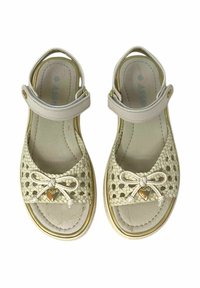 Sandali in crema intrecciati con una cinghia liscia di colore chiaro. Presentano un dettaglio a fiocco e un accento dorato. Soletta imbottita e suola testurizzata.