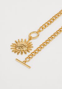 Colar em tom de ouro com um pingente de sol, apresentando uma superfície texturizada e raios, preso a uma corrente com fecho de gancho.