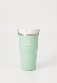 Tasse de voyage isolée Stanley de couleur vert menthe avec un couvercle blanc et une poignée en acier, sur fond blanc uni.