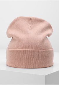 Berretto lavorato a maglia rosa chiaro con cima morbida e polsino a costine. Tessuto soffice, design scomodo, senza motivi visibili o accessori.
