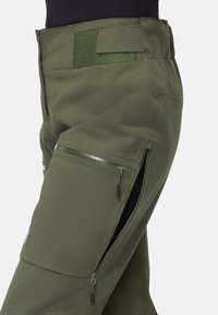 Olivgröna byxor gjorda av slitstarkt tyg, med dragkedjeförsedda sidofickor och en ruggad midja. Slim fit med strömlinjeformade designdetaljer.