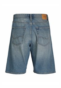 Pantaloni corti in denim azzurro chiaro, con taglio dritto, due tasche posteriori e una toppa in pelle sulla vita. Texture strappata visibile.