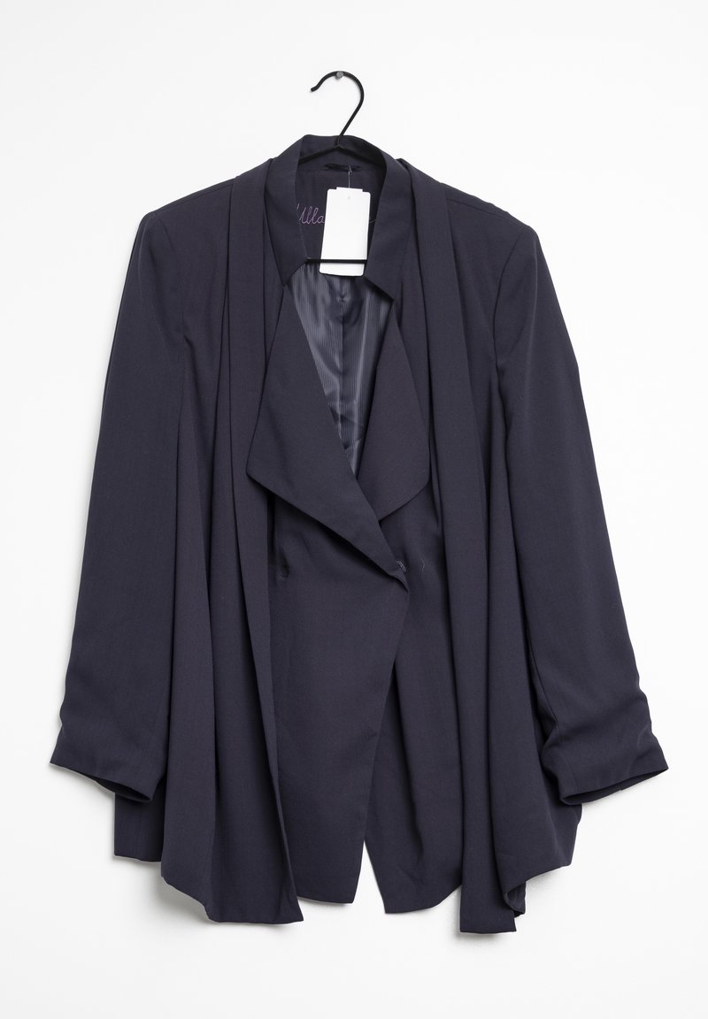 Tmavě námořnický modrý závěsný blazer s dlouhými rukávy zavěšený na černém ramínku na bílém pozadí.