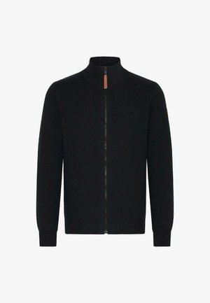 Črni pulover z zadrgo in visokim ovratnikom, rebrasti manšeti in pas. Gladka pletenina, s podrobnostjo zadrge iz rjave usnje.