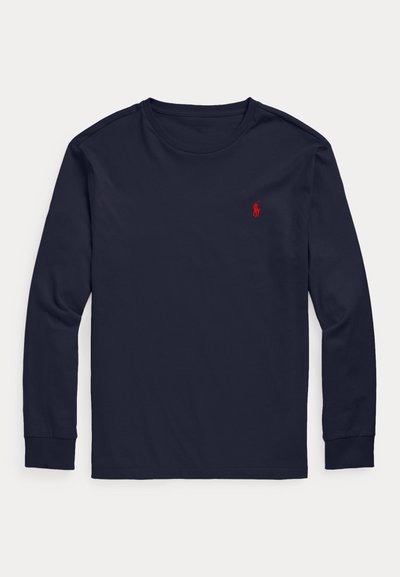 Tengerészkék, hosszú ujjú, kerek nyakú póló, bal mellrészen kis piros hímzett pólló játékos logóval.