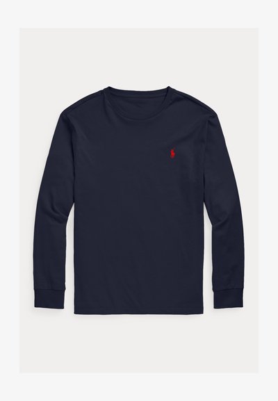 Tengerészkék, hosszú ujjú, kerek nyakú póló, bal mellrészen kis piros hímzett pólló játékos logóval.