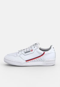 White Adidas low-top sneaker with red and navy stripes, perforated details, and black Adidas logo on the side and heel.