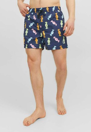 Shorts da bagno blu navy con un motivo di caramelle multicolore, vita elastica con cordino, taglio fino al ginocchio e tessuto leggero.