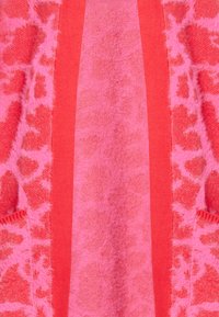 Rosa hoodie med ett texturerat mönster av leopardtryck, accentuerad med enfärgade rosa ränder längs kanterna och ner framsidan.