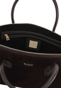 Brown suede handbag with gold zipper, leather handles, interior zip pocket, and branded logo plaque. Rectangular shape, spacious design.