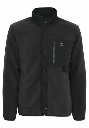 Must mustaga, kõrge kraega, rinna luku taskuga, nööbiga sulgemise ja küljetaskutega. Pehme tekstuur, vastupidav kangas.