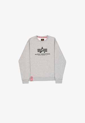 Szara bluza z okrągłym dekoltem, z czarnym logo "ALPHA INDUSTRIES" i czerwoną metką akcentującą na dolnym brzegu. Mieszanka bawełny, casualowy design.