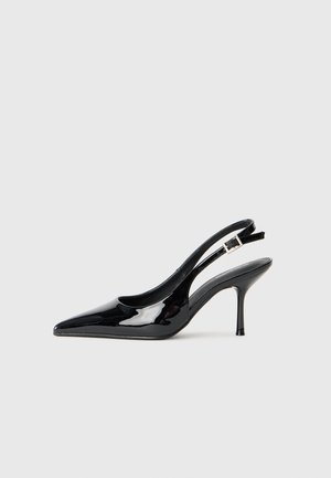 Sorte lakk pelle slingback pumpe med spiss tå og slank hæl. Har en justerbar spennestropp bak. Jevn tekstur.