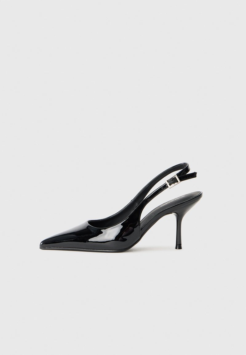 Sorte lakk pelle slingback pumpe med spiss tå og slank hæl. Har en justerbar spennestropp bak. Jevn tekstur.