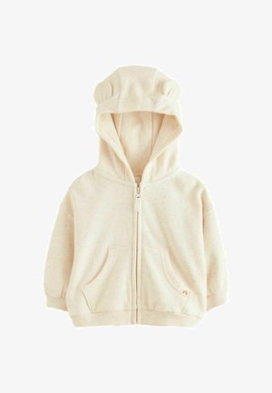 Bežna zip-up kapuca s ušima medvjedića na kapuljači, dva prednja dzepa i mrljav tekstur. Mekan materijal s rebrastim manžetama i rubom.