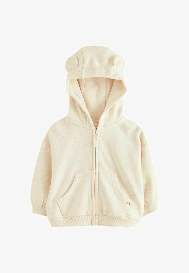 Bež zip-sveštrana s kapuljačom s ušima medvjedića, dva prednja džepa i točkasta tekstura. Mekani materijal s rebrastim manžetama i donjim rubom.