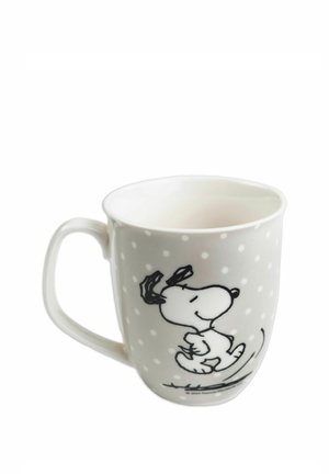 White ceramic mug with small white polka dots and a black-and-white illustration of Snoopy dancing on the side.