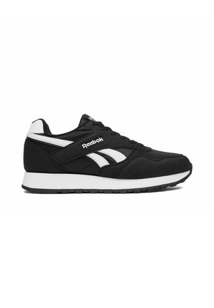 Scarpa da ginnastica Reebok in bianco e nero con suola bianca, logo laterale e design con lacci, mostrata di profilo su uno sfondo bianco.
