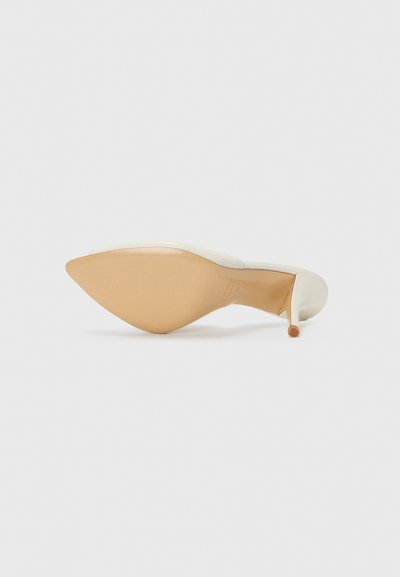 Pantof cu toc înalt, cu vârf ascuțit, superior sintetic de culoare crem și talpă bej. Textură netedă cu un toc subțire, stilettos.