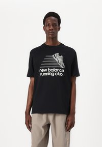 Juodas medvilnės marškinėliai su balta grafika, vaizduojančia bėgimo batelį, ir tekstu „new balance running club“ dideliais šrifto rašmenimis. Trumpomis rankovėmis, apvaliu kaklu.