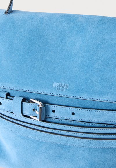 Sac à main Moschino Milano en daim bleu avec un détail de ceinture à boucle argentée sur le devant.