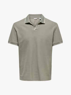 Polo à manches courtes vert olive clair avec un col et une petite encoche en V à l'encolure.