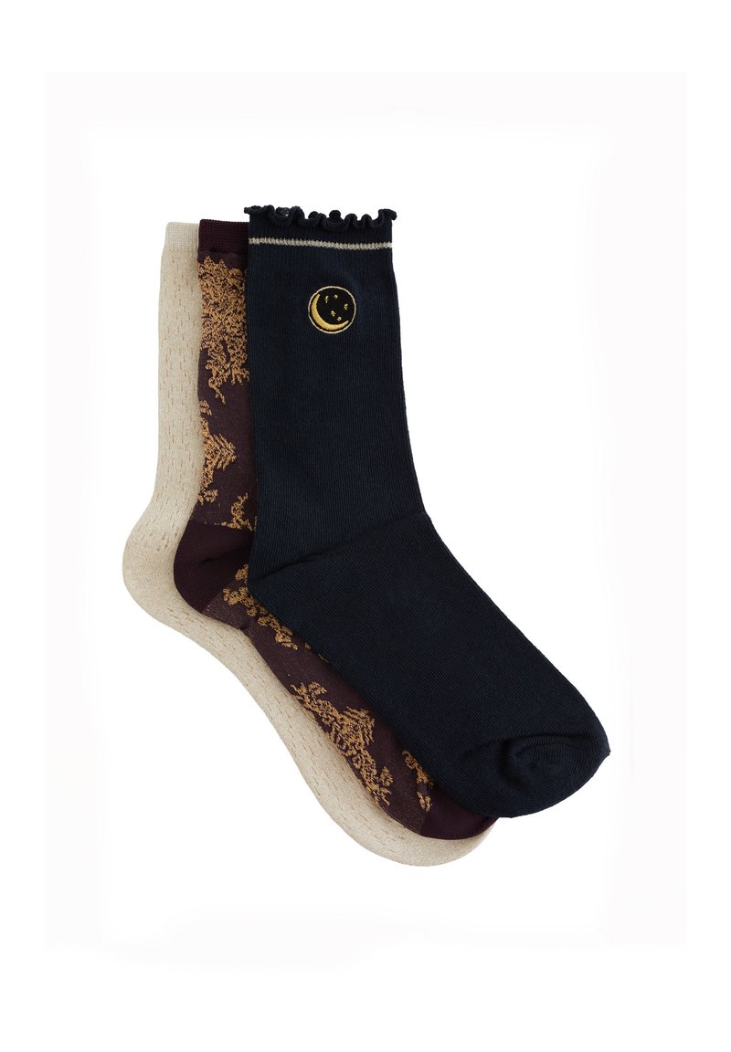 Sokker i blandede farver: en mørkeblå med et gyldent måneemblem, en beige med et bordeaux blomstermønster. Afsluttet med en rynket kant.