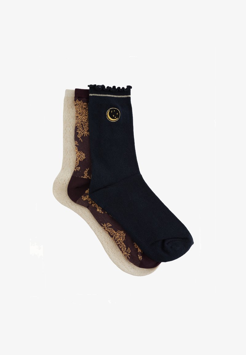 Sokker i blandede farver: en mørkeblå med et gyldent måneemblem, en beige med et bordeaux blomstermønster. Afsluttet med en rynket kant.
