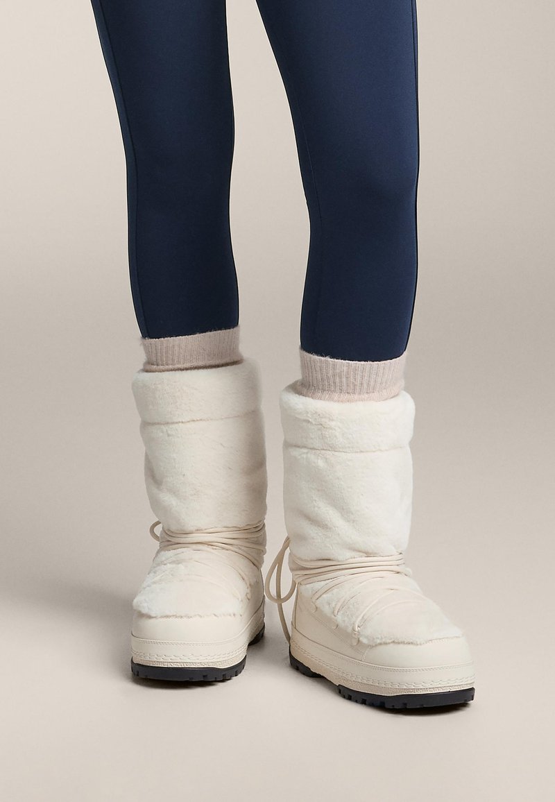 Hvide støvler foret med pels, med en tekstureret yderside, rundet tå, justerbare snørebånd og gummisål for godt greb.