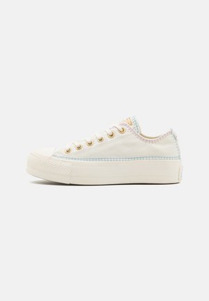 Leichte Sneaker aus Canvas in Off-White mit blauen und pastellfarbenen Stickereien, goldenen Ösen und einer strukturierten Gummisohle.