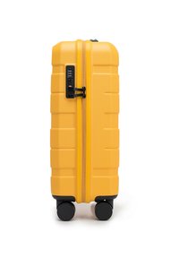 Valigia rigida gialla con superficie texture, doppia cerniera, lucchetto combinato e quattro ruote nere per la mobilità.