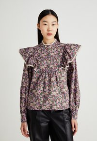 Blomstrete bluse med store volang-ermer, prydet med en blanding av rosa og kremfargede blomster på en brun bakgrunn, ferdig med blondedetaljer.