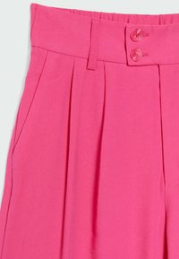 Różowe spodnie o wysokim stanie wykonane z teksturowanej tkaniny, z dwiema kieszeniami z przodu, wyraźnymi zakładkami i dwoma pasującymi guzikami w talii.