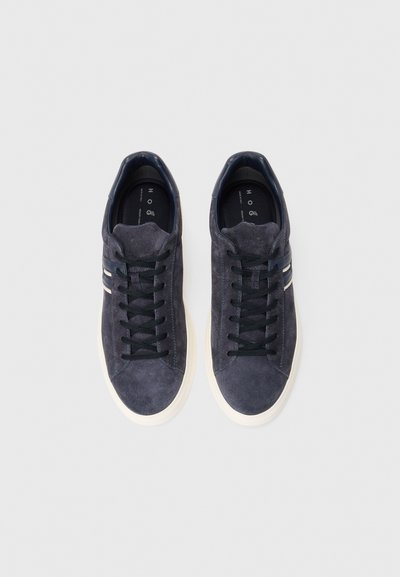 Navy suede sneakers with black laces and white rubber soles, viewed from above on a white background.