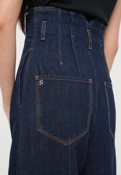 Pantaloni din denim închis, cu talie înaltă, cusături portocalii, două buzunare spate și un mic detaliu cu logo argintiu pe buzunarul din dreapta.