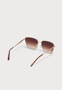 Metallic Sonnenbrille mit geometrischem Rahmen, braunen Verlaufsgläsern und braunem gemustertem Bügel. Mit verstellbaren Nasenpads für zusätzlichen Komfort.