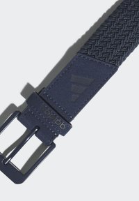 Marinevevd belte med teksturert stoff, som har et glatt faux skinnbånd og en matt spenne, med preget merkevare på skinnfanen.