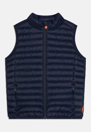 Marineblauwe gewatteerde mouwloze vest met ritssluiting aan de voorkant en hoge kraag, voorzien van een kleine oranje knop en een logo patch aan de onderkant.
