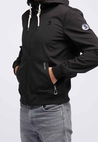 Svart zip-up hoodie med fodrad huva, vita snören, fickor med dragkedja på framsidan och logotyp patch på ärmen. Stretchigt, slätt tyg.