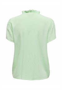 Hellgrünes Kurzarm-Oberteil mit einem strukturierten Muster und rüschigem Ausschnitt. Weicher Stoff mit lockerer Passform. Keine sichtbaren Verschlüsse.