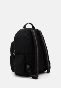 Musta kankainen reppu, jossa on pehmustetut olkahihnat, ylhäältä löytyvä kantokahva, vetoketjulliset osastot, sivutasku sekä erottuva harmaa kontrastitikkaus.